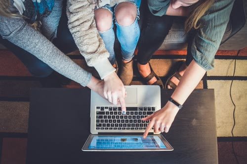 People reviewing a laptop screen